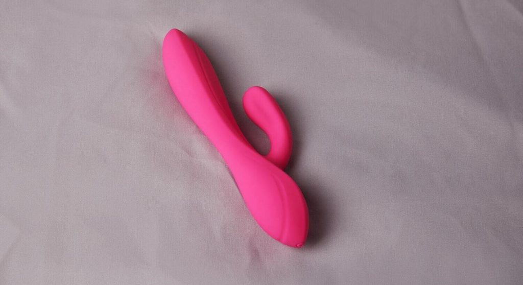 A bright pink rabbit vibrator on a grey background