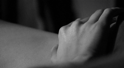 A hand touching the skin of another person’s curves