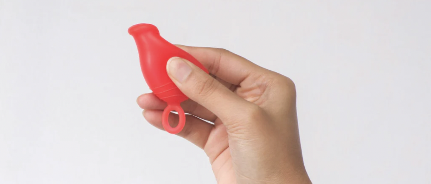 hand creating a punch-down insertion fold with the Asan menstrual cup